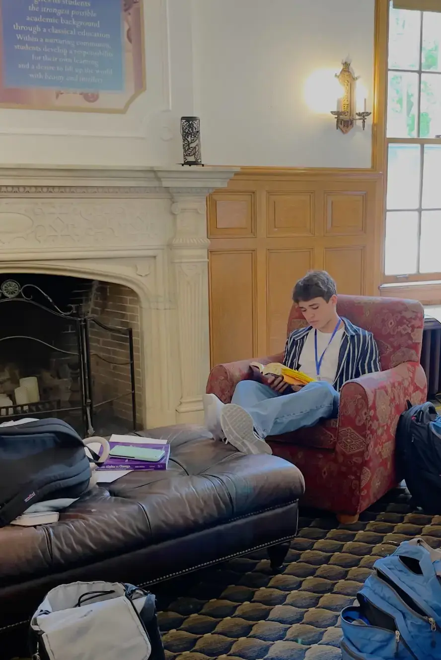 Student reading in armchair